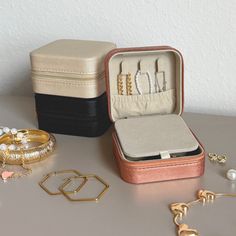 an open jewelry box sitting on top of a table next to bracelets and rings