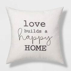 a white pillow with black lettering that says love build a happy home on the front