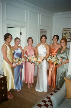 a group of women standing next to each other holding bouquets