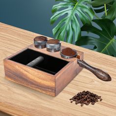 a wooden box with spice and seasoning in it sitting on a table next to a plant