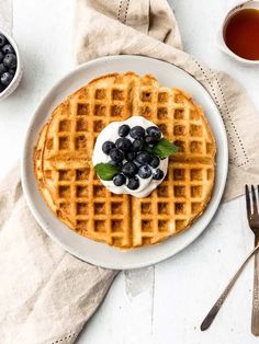 a white plate topped with waffles covered in blueberries