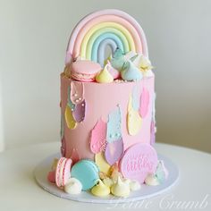 a birthday cake decorated with pastel colors and rainbows