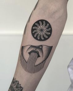 a black and white tattoo on the arm of a person with a sun and moon