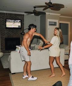 a man and woman are dancing in the living room