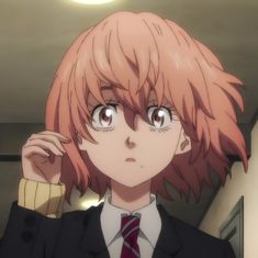 an anime character in a suit and tie with his hand up to his ear, looking at the camera