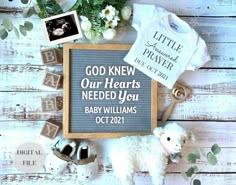 a baby's first year announcement is displayed on a white wooden background with flowers and other items