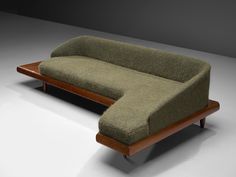 a green couch sitting on top of a wooden frame