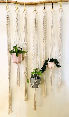 macrame plant hangers are hung on the wall with rope and plants in them