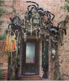 a house decorated for halloween with fake spider webs and decorations on the front door