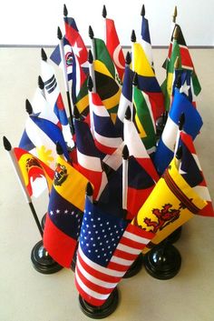 a bunch of flags sitting on top of a table next to each other in a vase