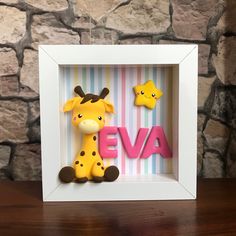 a giraffe is sitting in a shadow box with the word eva on it