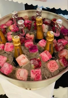 several bottles of champagne and roses in ice cubes