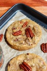 three pecan cookies sitting on top of a baking sheet