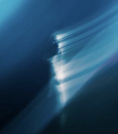 a blurry image of the ocean with waves in blue and white colors, as seen from above