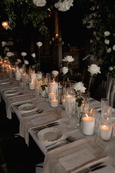 a long table is set with candles and place settings