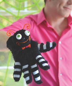 a man holding up a black and white stuffed animal