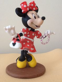 a minnie mouse figurine is posed on a table