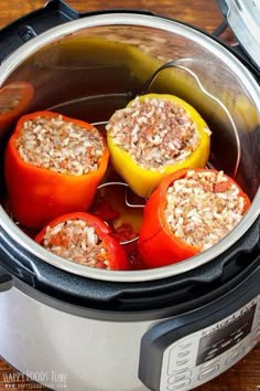 three stuffed peppers are in the slow cooker