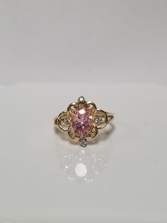 "Thanks for shopping our vintage estate store. We tend to sell well below wholesale and truly hope you enjoy all of our items. Many of the items are one of a kind, so please enjoy scrolling through the pictures and hopefully something will catch your eye. Brown spots are from camera or reflections. Estate 10k yellow gold created pink 1.5ct ice cz diamond filigree cocktail ring.  White gems are cz diamonds also.  Ring size: 5.75 Gem: 8mm by 5mm Setting: 1/2\"  Band Width: 1.5mm Weight: 2.70 grams Sweet ring, one that you will love. Marked 10K." Vintage Diamond Cluster Ring With Accent Stones, Classic Pink Cluster Ring For Anniversary, Vintage Collectible Birthstone Ring, Vintage Pink Diamond Ring Hallmarked, Vintage Cluster Ring With Accent Stones For Formal Occasions, Vintage Pink Diamond Ring With Hallmark, Vintage Yellow Gold Cubic Zirconia Ring, Vintage 14k Stamped Oval Diamond Ring, Vintage Oval Diamond Ring Stamped 14k