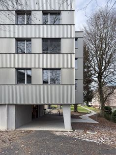 an apartment building with several windows on the side and one door open to let in light