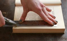 a person is using a ruler to read a book