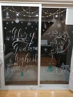 an open window with writing on it and christmas decorations hanging from the windowsills