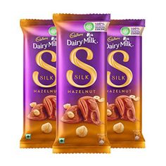 three bags of dairy milk sit next to each other in front of a white background