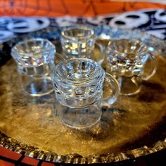 small glass cups sitting on top of a metal tray