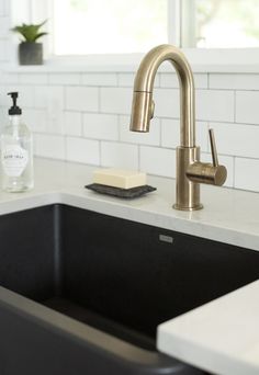 a kitchen sink with a soap dispenser next to it