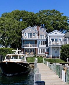 a boat is docked in front of a large house