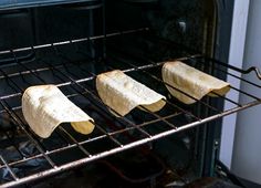 three tortillas are being cooked in an oven with the racks holding them open