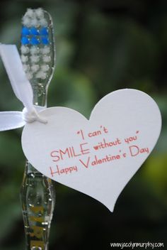 a toothbrush with a message attached to it next to a glass filled with water