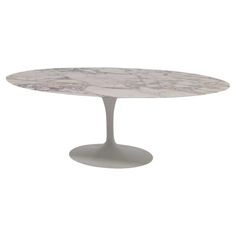 an oval marble dining table with white legs and a circular base, on a white background