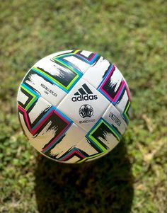 a soccer ball sitting on top of a lush green field