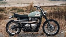 a motorcycle parked on the side of a dirt road