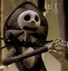 a skeleton dressed as jack skellingy holding scissors