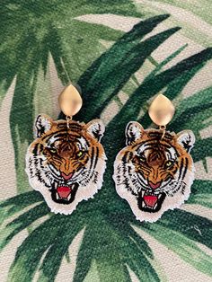 Go Tigers! Take a walk on the wild side in these fiercely roaring tiger dangle earrings. Fashioned from vividly colored embroidered tiger patches and hung from gold tone eye shaped finials, these earring are sure to show your tiger pride, spirit and enthusiasm.  Total Length: 3 inches Total Width: 2 inches Lightweight for a comfortable wear! Tiger Roar, Embroidered Tiger, Tiger Roaring, Go Tigers, Walk On The Wild Side, Aesthetic Desktop Wallpaper, Eye Shapes, Finials, Desktop Wallpaper