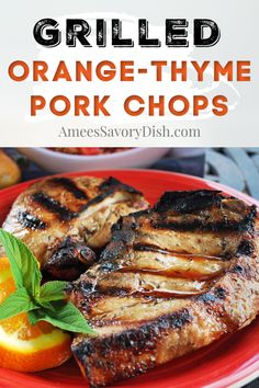 grilled orange thye pork chops on a red plate with an orange slice