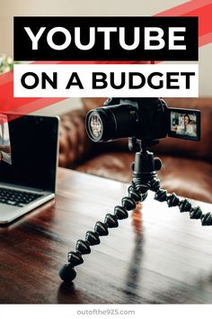 a camera sitting on top of a wooden table next to a laptop