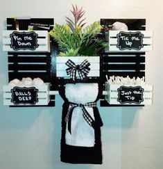 a potted plant sitting on top of a wooden shelf next to towels and other items