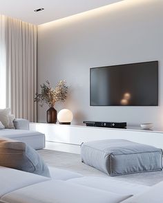 a large flat screen tv mounted on the wall in a living room with white furniture