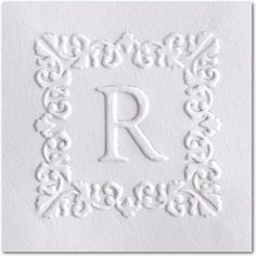 the letter r is made out of white paper and has an intricate border around it