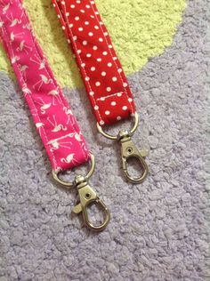 two pink and red lanyards with polka dots on them, one has a pair of scissors