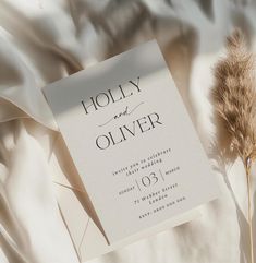 an elegant wedding card with the word holly and oliver written in black on it