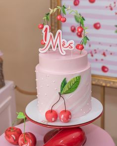 a pink cake with cherries on top and the word mee spelled in white