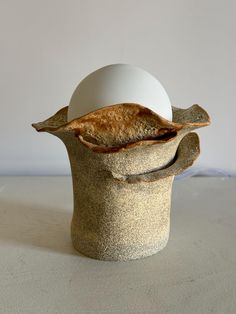 an egg sitting on top of a stone vase