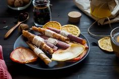 an assortment of food on a plate with orange slices and other foods in the background