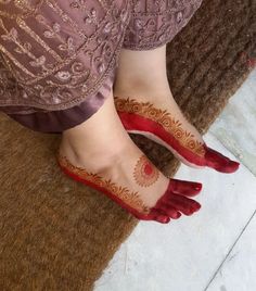 a woman's feet with hennap and red shoes