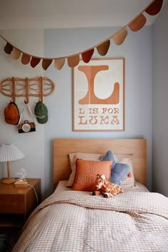 a bed room with a neatly made bed and pictures hanging on the wall above it