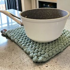 a white bowl sitting on top of a green place mat next to a pair of tongs